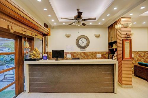 a lobby with a bar with a clock on the wall at Hotel Atlantis Continental in New Delhi