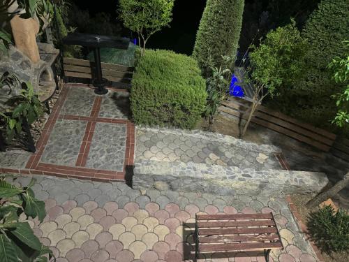 a park with a bench and a fence and bushes at Villa Kastelas in Kato Asites