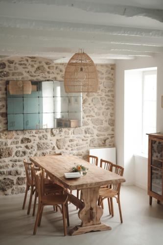 une salle à manger avec une table et des chaises en bois dans l'établissement Maison rénovée à 80m de la plage, charme et confort, à Saint-Jacut-de-la-Mer