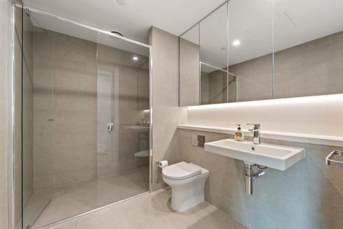 a bathroom with a toilet and a sink and a shower at Luxury Retreat 2BR with Stunning Harbour Bridge & City Views in Sydney