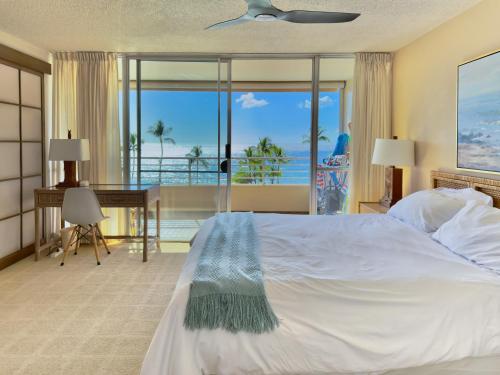a bedroom with a bed with a view of the ocean at Stunning ocean view 2 bedroom Steps from beach in Kihei