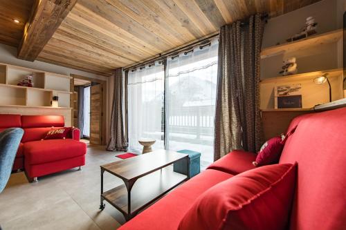 un salon avec un canapé rouge et une table dans l'établissement Appartement neuf en hyper centre station - 8/9 personnes, à Saint-Sorlin-dʼArves