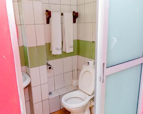 a small bathroom with a toilet and a sink at Pinebreeze Holiday Resort in Nyali