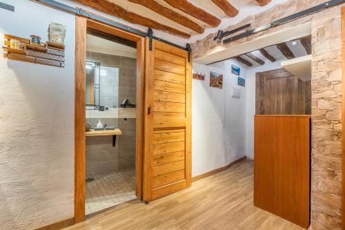 a bathroom with a wooden door and a sink at Apartamentos cuna del Genil in Güéjar-Sierra