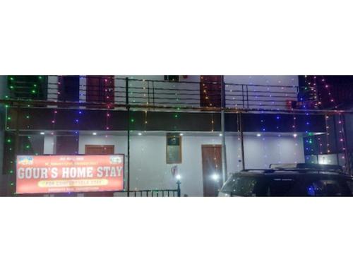 a house with a sign in a window with a car at Gaurs home stay badrinath Highway, Pandukeshwar in Pāndukeshwar