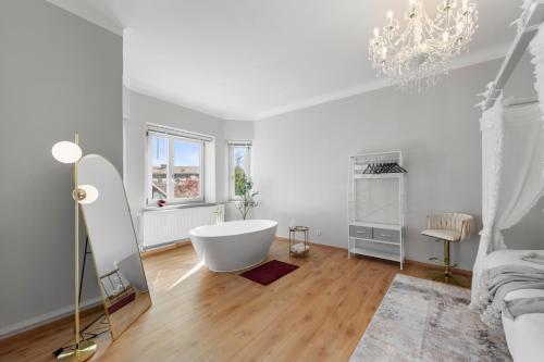 a white bathroom with a tub and a chandelier at Liebelei Miesbach Boutique Apartment - 2 Min zum Bahnhof, eigener Parkplatz in Miesbach