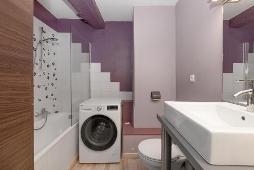 a bathroom with a washing machine and a sink at Maison Tendat in Albi