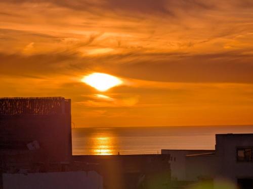 a sunset over the ocean with the sun in the sky at Tayyurt Surf Camp Tamraght Aourir in Awrir