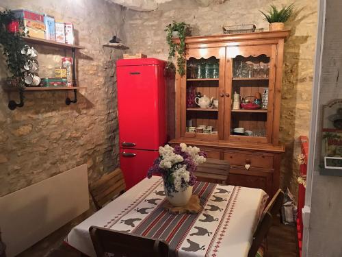 Cette chambre dispose d'un réfrigérateur rouge et d'une table avec des fleurs. dans l'établissement Maison typique Périgourdine avec piscine, à Saint-Martial-de-Nabirat