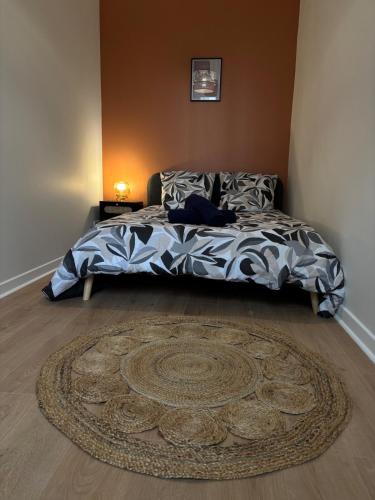 une chambre avec un lit avec un tapis sur le sol dans l'établissement Le Charmant - Proche Gare, à Villeurbanne