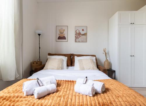 une chambre avec un grand lit avec des serviettes dessus dans l'établissement Appartement cosy proche de Paris, à Asnières-sur-Seine