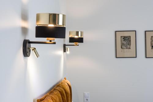 a lamp on a wall next to a couch at Karoso rezidencija in Klaipėda