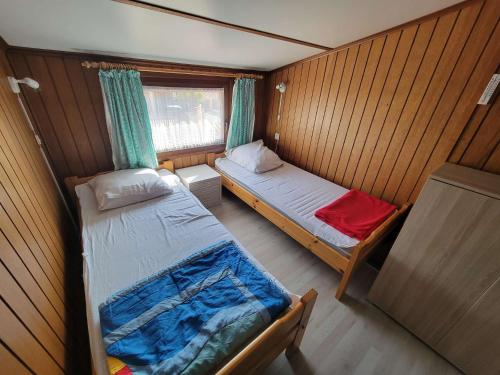 une petite chambre avec deux lits et une fenêtre dans l'établissement Belle villa d'angle climatisée, residence TAMARIS, wifi, 2 chambres 4 couchages PORTIRAGNES PLAGE LRTAMM1, à Portiragnes