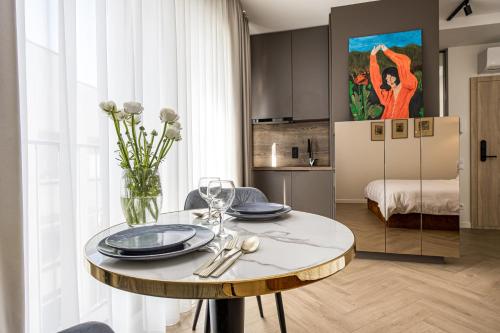 a dining room with a table and a room with a bed at Karoso rezidencija in Klaipėda