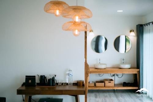 a room with a mirror and a table with a lamp at Cozy Homey Doichang in Ban Muang Ngam