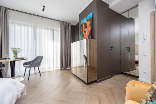 a bedroom with a bed and a table and a cabinet at Karoso rezidencija in Klaipėda