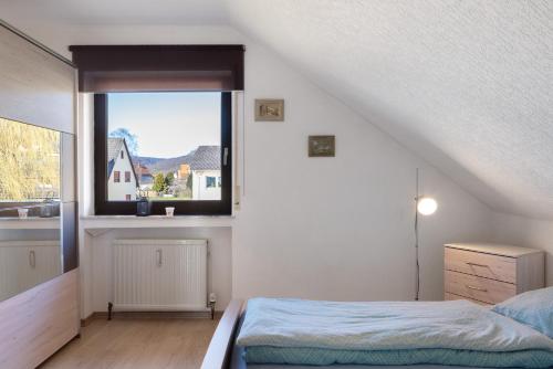 a bedroom with a bed and a large window at Heidi's Panoramablick in Neuerode