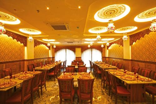 ein Esszimmer mit langen Tischen und Stühlen in der Unterkunft Hotel Surya Palace in Gandhinagar