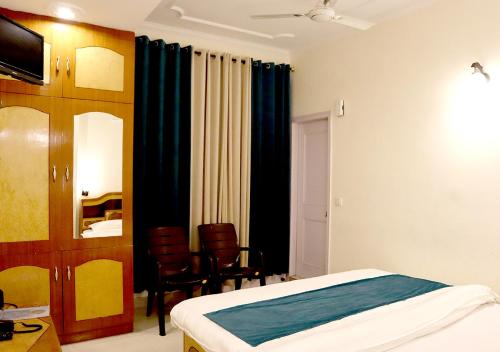 una habitación de hotel con una cama y un espejo en Hotel Sanawar View, en Kasauli
