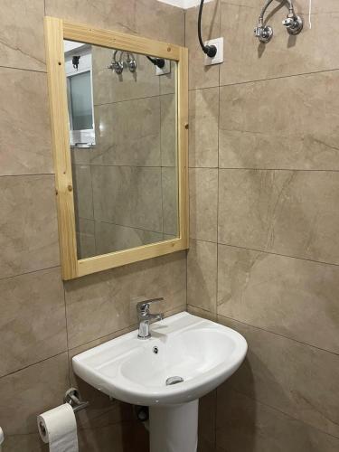 a bathroom with a sink and a mirror at Casa Tubarào in Vila do Maio