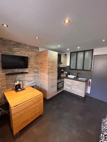 une grande cuisine avec une télévision et une table dans l'établissement Adorable studio, aux Lecques