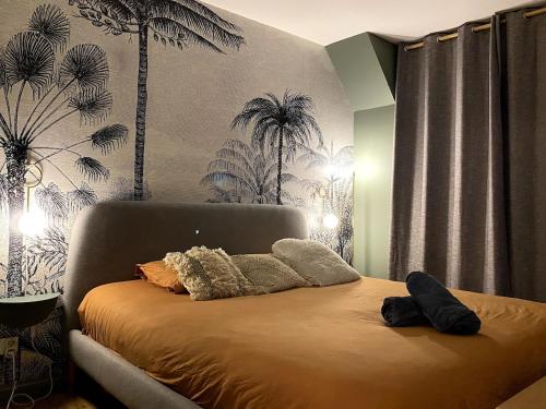 - un lit dans une chambre avec des palmiers sur le mur dans l'établissement Le Duplex avec Rooftop, à Lyon