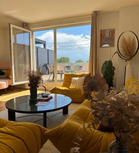 un salon avec un canapé jaune et une table dans l'établissement Le Duplex avec Rooftop, à Lyon
