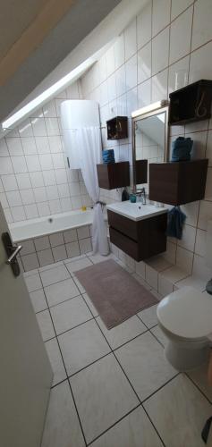 a bathroom with a sink and a toilet and a mirror at Auszeit in Wald-Michelbach