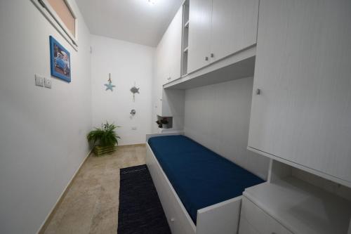 a small room with a blue bed in a room at Hiram House in La Maddalena