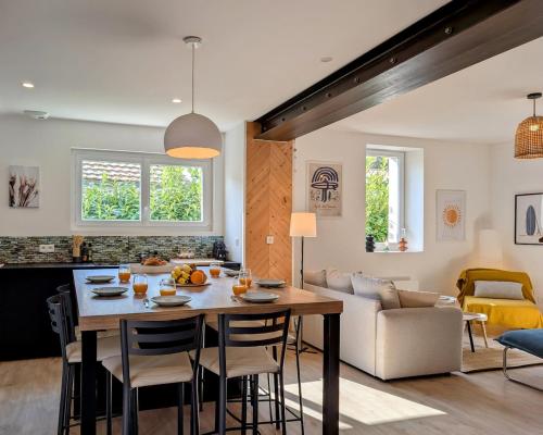 une cuisine et un salon avec une table et des chaises dans l'établissement La villa Brévinoise - Elégante maison pour 6 personnes, à Saint-Brévin-les-Pins