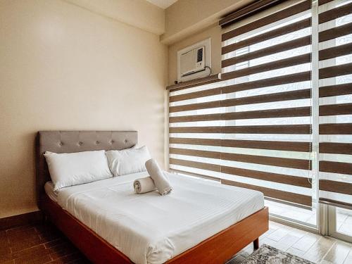 Un dormitorio con una cama con un osito de peluche encima. en Best Family Suite Experience, en Iloilo City