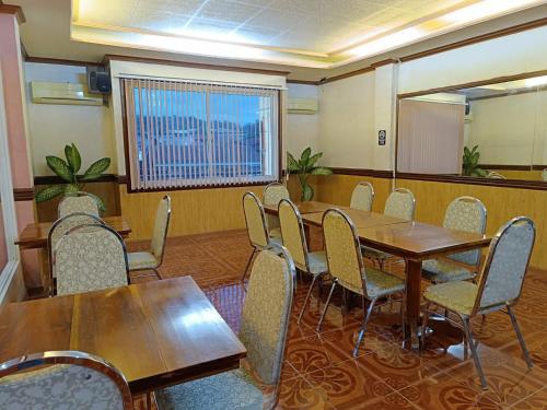 a conference room with wooden tables and chairs at Northomes Pensione by HiveRooms in Bogo