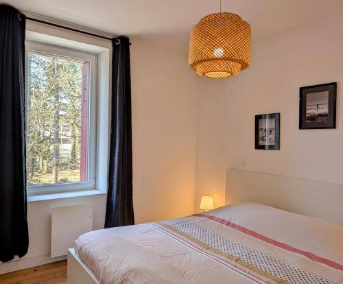 une chambre avec un lit et une fenêtre dans l'établissement La villa Brévinoise - Elégante maison pour 6 personnes, à Saint-Brévin-les-Pins