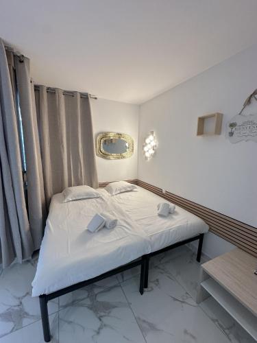 une petite chambre avec un lit blanc et une fenêtre dans l'établissement Résidence Graziella Studio 107, à Juan-les-Pins
