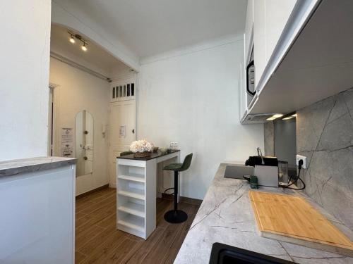 a white kitchen with a counter and a desk at ⁂ 600m port tramway clim wifi in Nice