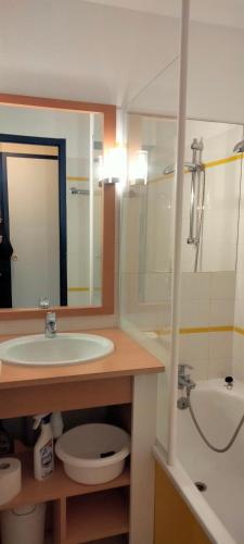 une salle de bain avec un lavabo, des toilettes et un miroir dans l'établissement résidence port bourgenay studio 5 personnes, à Talmont-Saint-Hilaire