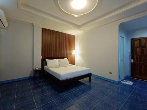 a bedroom with a bed with a wooden headboard at Northomes Pensione by HiveRooms in Bogo