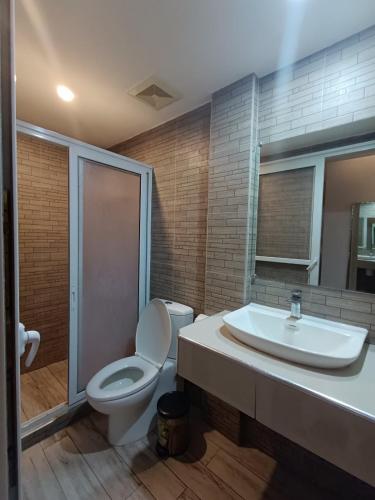 a bathroom with a toilet and a sink at Northomes Pensione by HiveRooms in Bogo