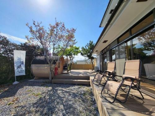 quelques chaises assises à l'extérieur d'une maison dans l'établissement ALL SEASON RESORT No6 Shiokaze, à Ichinomiya