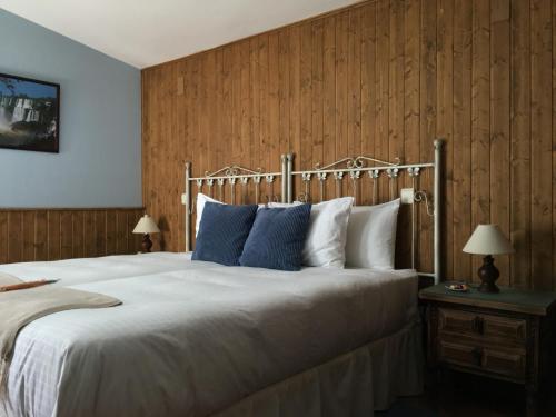 ein Schlafzimmer mit einem großen weißen Bett mit blauen Kissen in der Unterkunft La Guarida del Oso in Candeleda