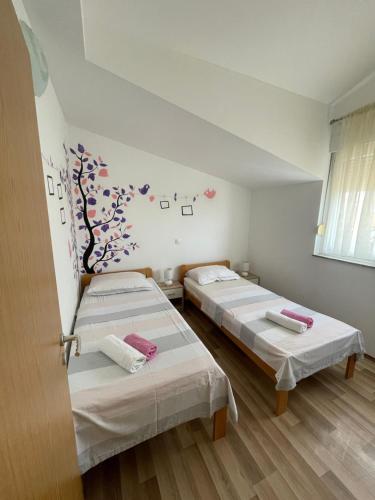 dwa łóżka w pokoju z sercami na ścianie w obiekcie Apartmani Krišto 2 Zadar w mieście Zadar