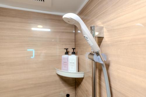 a white hairdryer on a wall in a bathroom at Mi-HOTEL UENO in Tokyo