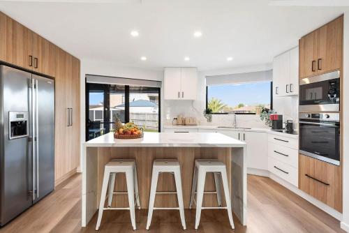 a kitchen with a large island with bar stools at Paradise on Peninsula in Safety Beach