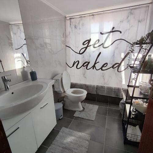 a bathroom with a toilet and a sign that says get made at Christina's house in Kipséli