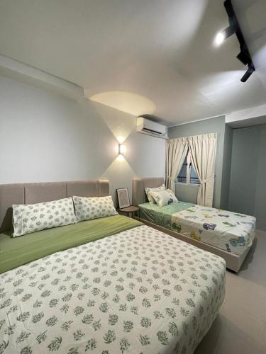 a bedroom with two beds and a window at Tiara Desaru Residence Private Beach Bandar Penawar by Ucome Homestay in Bandar Penawar