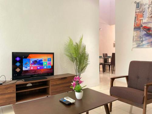 a living room with a television on a wooden entertainment center at Jovial Single Storey Cozy Haus 9Pax in Lunas