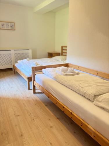 two beds in a room with wooden floors at Apartments Steinwänd in Grünau im Almtal