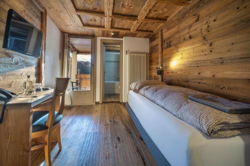 a bedroom with a large bed in a wooden wall at Hôtel Le Grand Chalet in Leysin