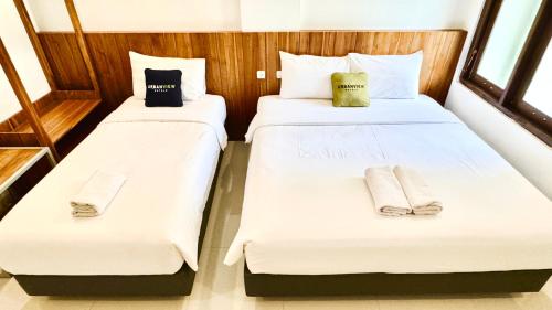 Una cama o camas en una habitación de Urbanview Code Riverstay Yogyakarta