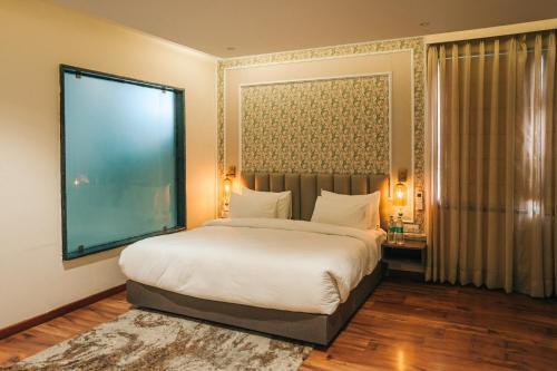 a bedroom with a large bed and a large window at New Hotel Snow Crest in Badrīnāth
